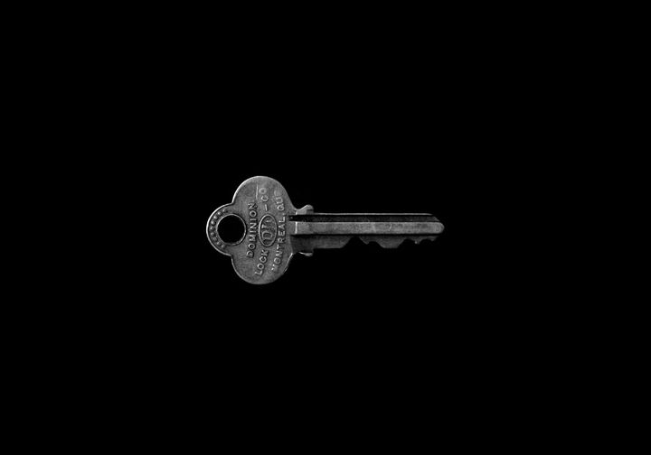 A key in front of a black background